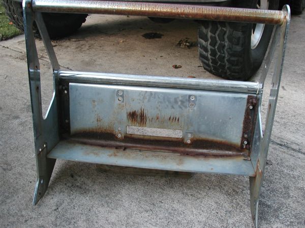 Galvanized steel fold-down step or tray fixture mounted to a frame on a concrete driveway