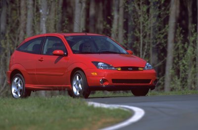 2002 Ford Focus - A red 2002 Ford Focus SVT is captured from a three-quarter front view on a winding road.
