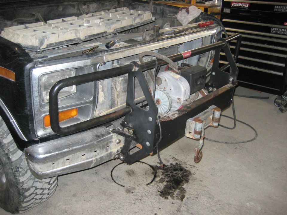 Front end of a 1980s Ford Bronco with a winch mounted on the aftermarket bumper