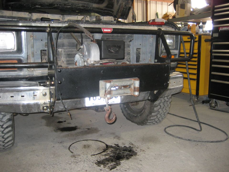 1986 Ford Bronco front end with winch and brush guard, parked in a garage
