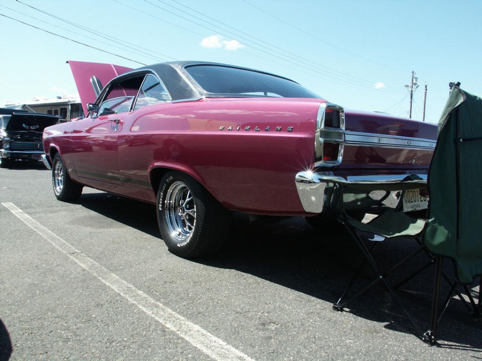 1966 Ford Fairlane 500 rear quarter view, maroon paint, black vinyl top, chrome bumper. Another car is visible in the background