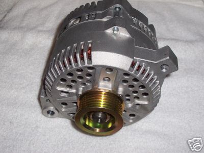 1986 Ford Bronco - Alternator part with a gold pulley, likely for a vehicle. Text overlay reads 'SUPERMOTORS'.
