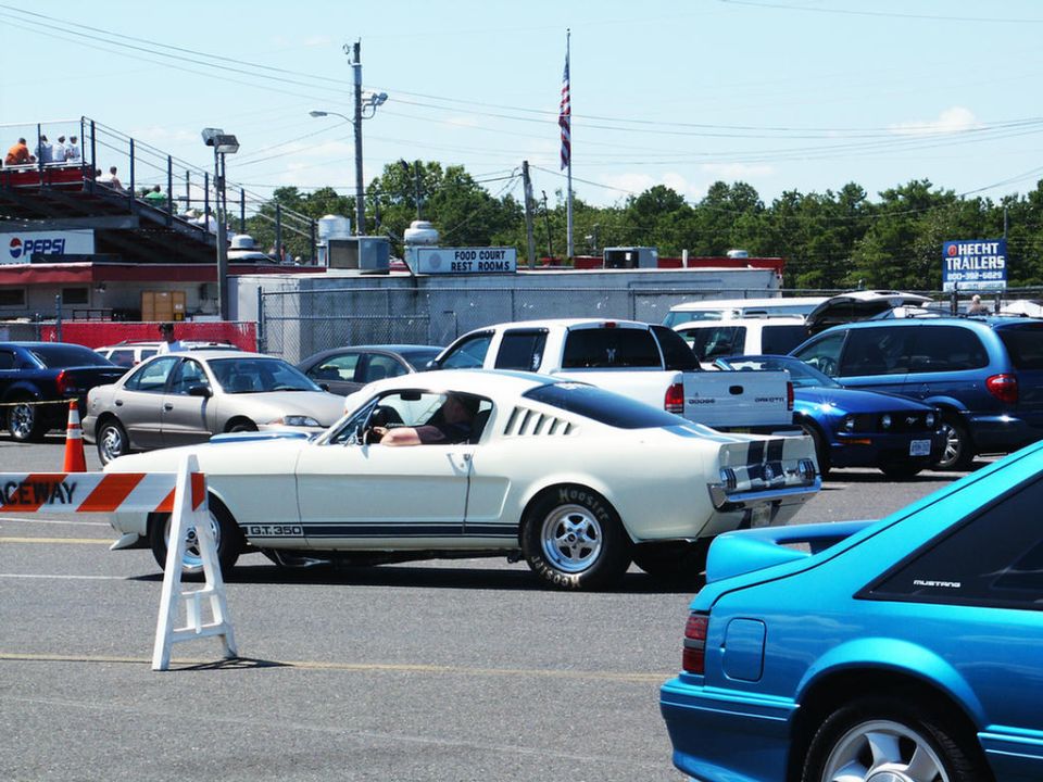White 1966 Ford Mustang GT350 side view with racing stripes and Hoosier tires