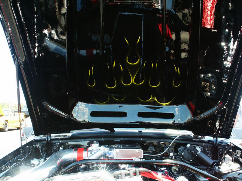 car hood interior with yellow flame decals and engine parts visible
