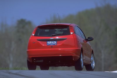 2002 Ford Focus - Rear view of a red 2002 Ford Focus hatchback driving on a road.