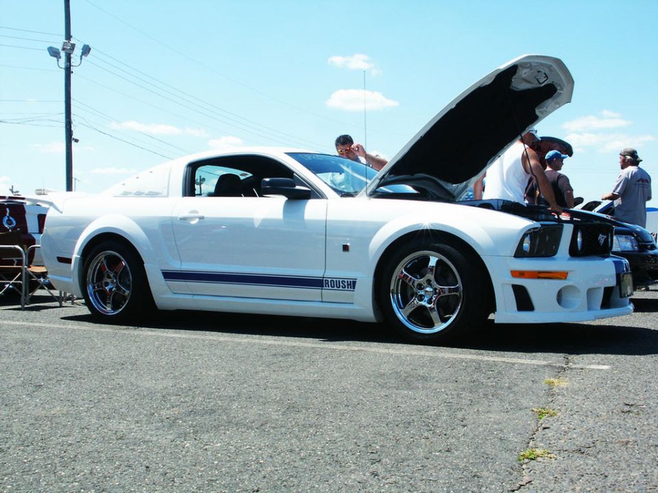 White Ford Mustang with blue racing stripes and ROUSH badging, hood open