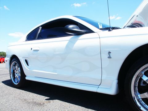 2001 Mercury Grand Marquis - A white coupe with grey flame decals and chrome wheels is parked outside on a sunny day.