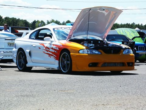 2001 Mercury Grand Marquis - A customized Ford Mustang is displayed with its hood open at an outdoor car show.