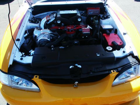 2001 Mercury Grand Marquis - The engine bay of a yellow car shows a supercharger and custom red ignition wires.