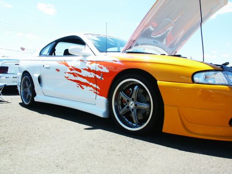 2001 Mercury Grand Marquis - A custom coupe with flame graphics and an open hood sits at a car show.