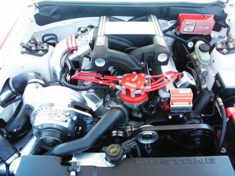 2001 Mercury Grand Marquis - Close-up view of a modified engine bay a supercharger and performance ignition components.