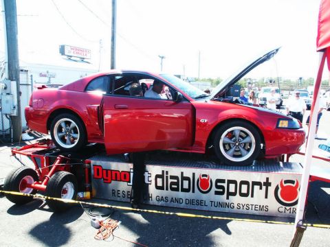 2001 Mercury Grand Marquis - A red 2001 Ford Mustang GT is positioned on a dynamometer with its hood open, likely for performance testing.