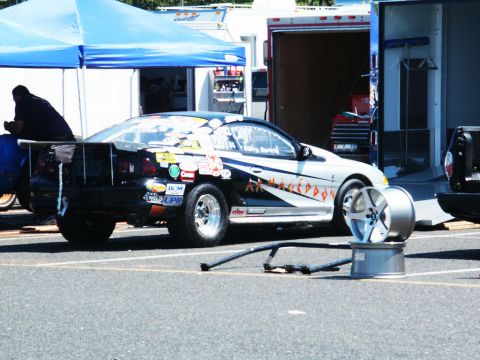 2001 Mercury Grand Marquis - Modified drag car with racing stickers and a spare wheel visible at a car show.