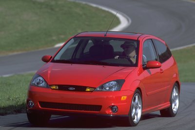 2002 Ford Focus - A red 2002 Ford Focus SVT is captured in a three-quarter front view on a track, highlighting its sporty design.