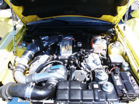 2001 Mercury Grand Marquis - The engine bay of a yellow vehicle, a prominent supercharger and custom modifications.