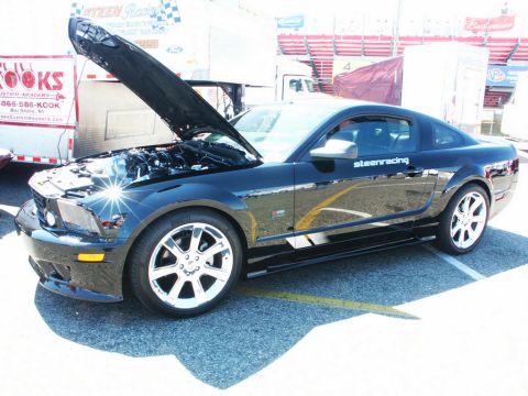 2001 Mercury Grand Marquis - A black Ford Mustang is parked with its hood open, revealing the engine compartment.