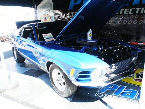 2001 Mercury Grand Marquis - A blue classic coupe, likely from the 1970s, is displayed with its hood open, revealing the engine and a bottle of Pennzoil.