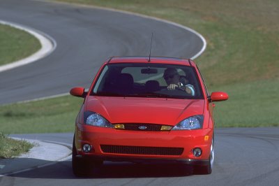 2002 Ford Focus - A red 2002 Ford Focus SVT is captured from the front as it navigates a curve on a race track.