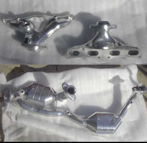 1997 Ford Taurus - This photo displays two exhaust manifolds and a catalytic converter, likely for a vehicle's exhaust system.