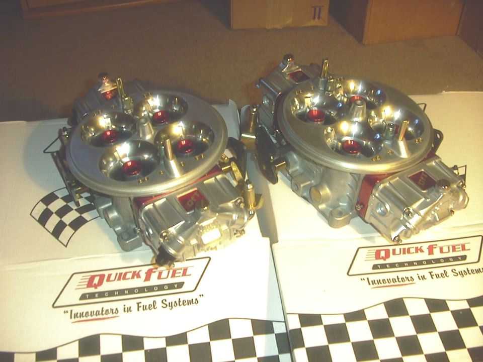 Two Quick Fuel Technology carburetors with red accents and checkered flag motif