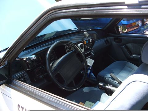 1987 Ford Mustang - Interior view of a 1987 Ford Mustang police car, showing the dashboard and seats.