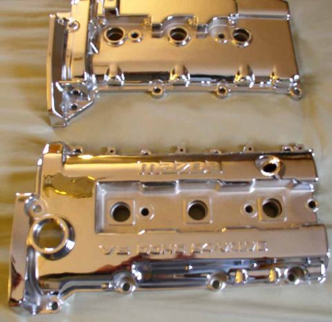 1996 Ford Probe - Two shiny chrome engine valve covers are displayed, one clearly showing the 'Mazda' logo.