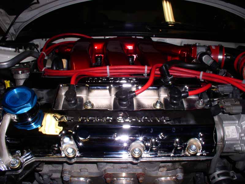Engine bay with chrome valve covers and red spark plug wires