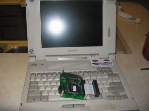 1991 Ford Bronco - A circuit board rests on the keyboard of an open Compaq laptop computer.