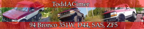 1996 Ford Bronco with red and white paint, lifted suspension, off-road tires, and a roll cage