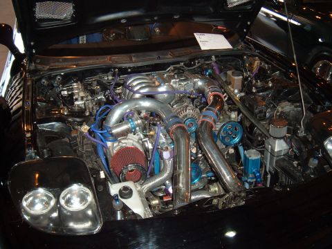 1991 Ford Probe - Engine bay of a modified car with prominent twin turbochargers and custom blue plumbing.