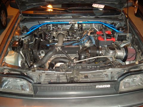 1991 Ford Probe - The engine bay of a Mazda is shown with various aftermarket parts installed.