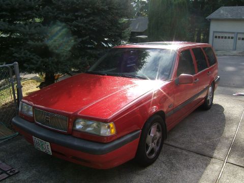 1987 Volkswagen Golf - This red Volvo 850 wagon is parked in a driveway with a garage in the background.