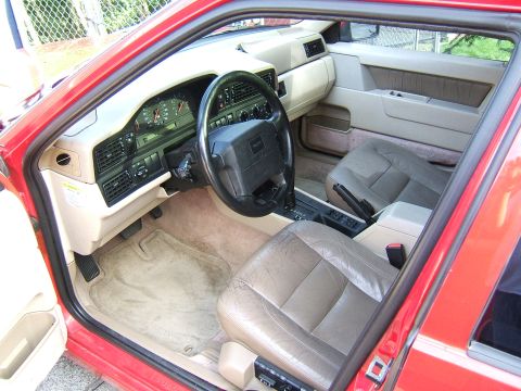 1987 Volkswagen Golf - Interior of a red Volvo 740 sedan, showing the dashboard, steering wheel, and seats.
