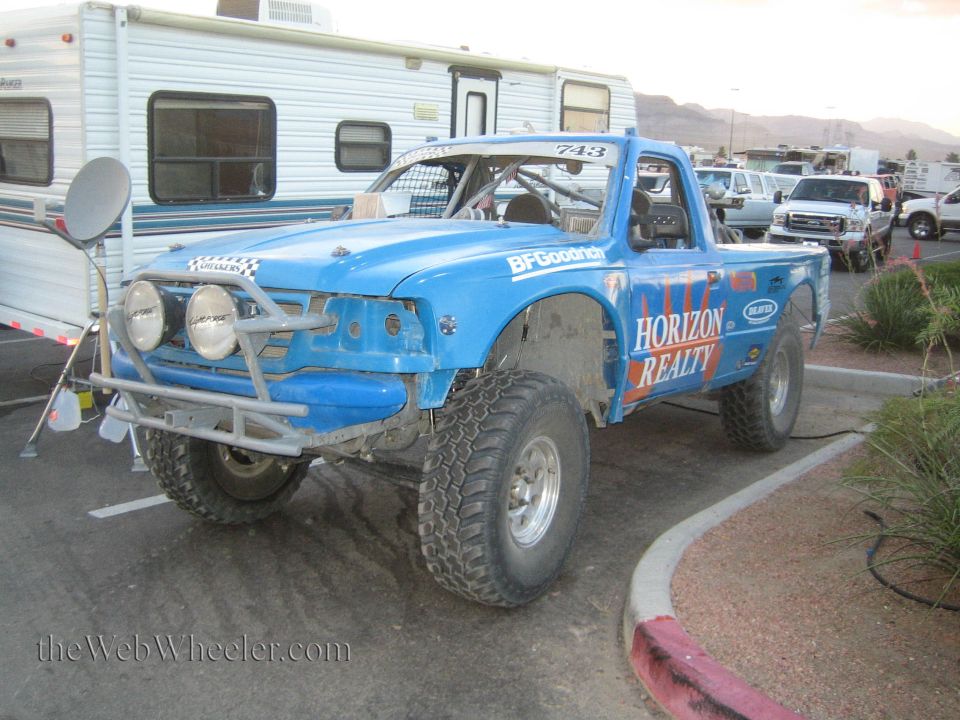 Blue Horizon Realty prerunner race truck parked beside an RV