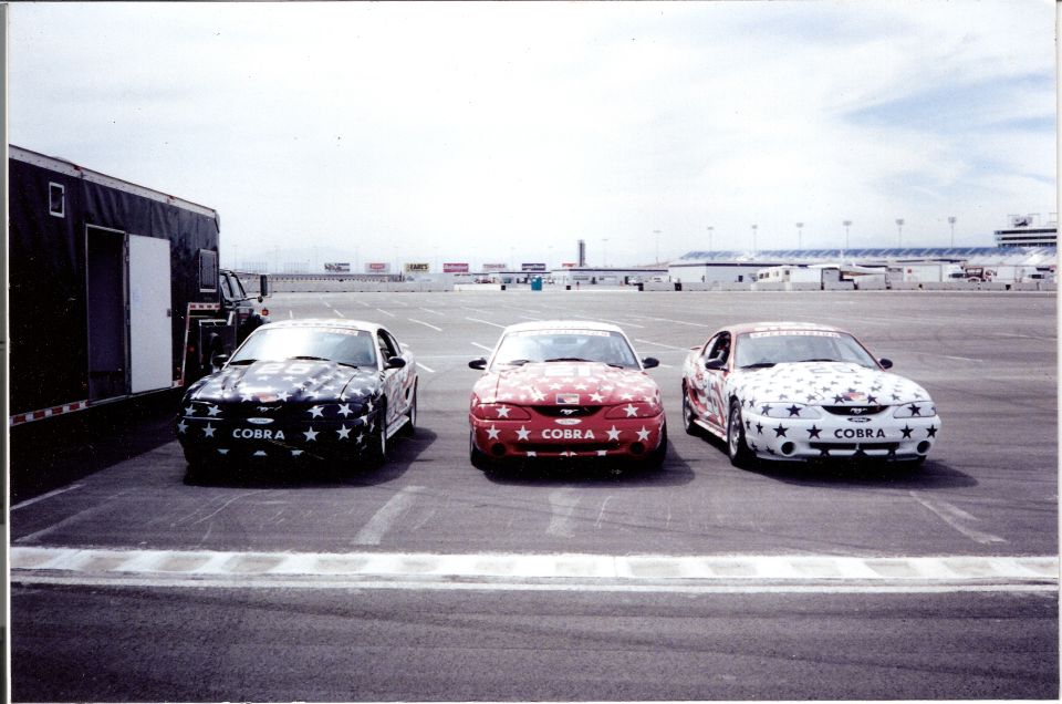 Three 1995 Ford Mustangs with star graphics and 'COBRA' text on the front