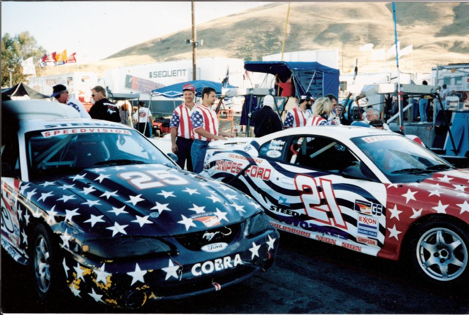 1995 Ford Mustang race cars with stars and stripes livery, one numbered 25, the other 21