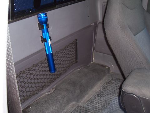 2003 Ford Ranger - Interior view of a truck cab showing a mounted blue flashlight and storage net.
