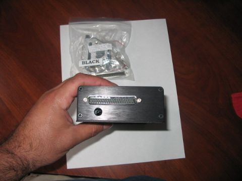 1991 Ford Bronco - A hand holds a black electronic device with a large connector, next to a bag of cables also labeled "BLACK".