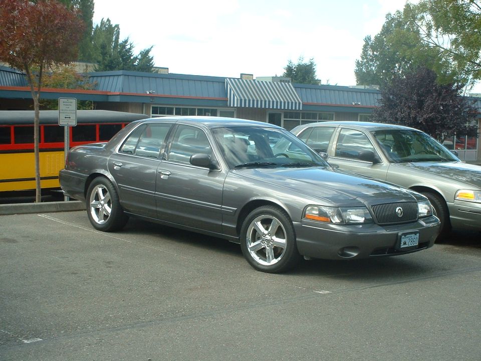 Gray 2000 Ford Crown Victoria parked next to another car, front 3/4 view