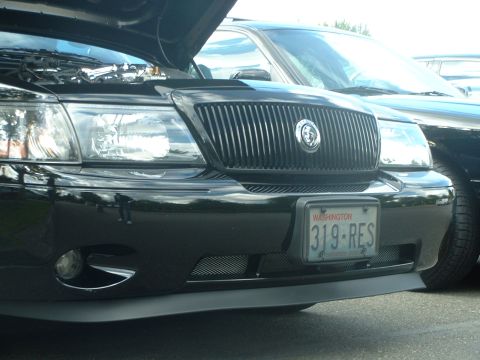 2000 Ford Crown Victoria - Front view of a black car with its hood open, a prominent vertical grille and a Washington license plate.