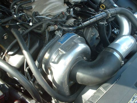 2000 Ford Crown Victoria - Close-up view of an engine bay, highlighting a polished supercharger and associated plumbing.