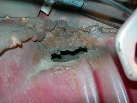 1992 Ford Taurus - Significant rust has eaten through the metal, creating a large hole.