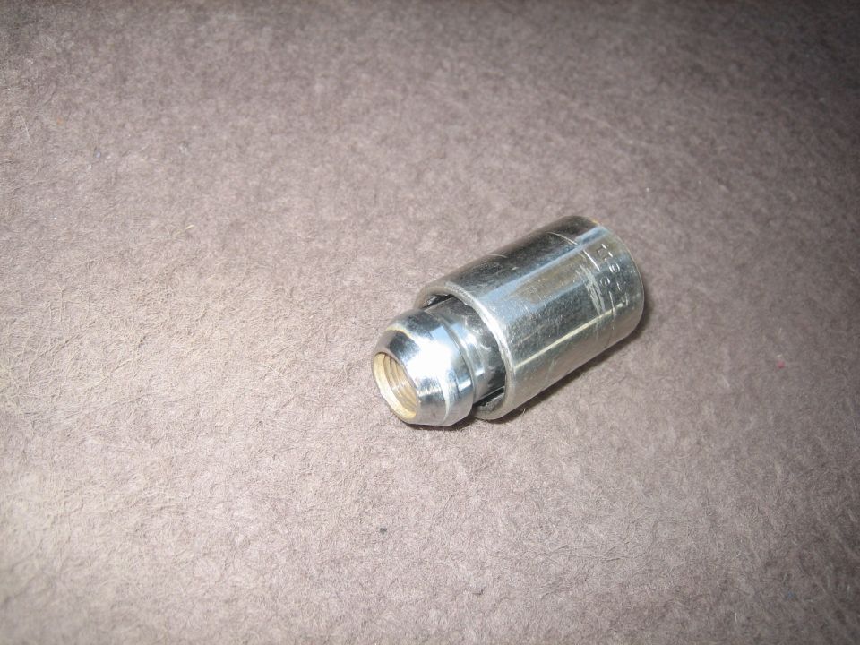 lug nut with a socket over it, on a textured surface