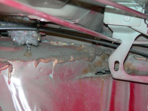 1992 Ford Taurus - Close-up of corroded metal and wiring within a vehicle's interior structure.