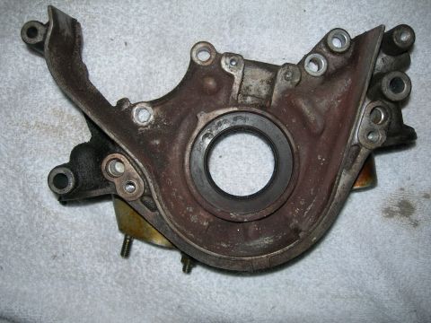 1992 Ford Taurus - This is a close-up view of a used engine timing cover, showing wear and a central seal.