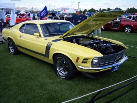 1972 Ford Ranchero - A yellow 1970 Ford Mustang Boss 302 is displayed with its hood open at an outdoor car show.