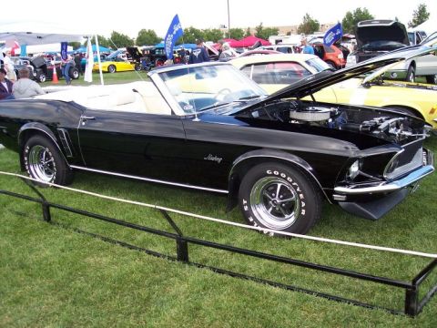 1972 Ford Ranchero - A black 1969 Ford Mustang convertible is displayed with its hood up at an outdoor car show.