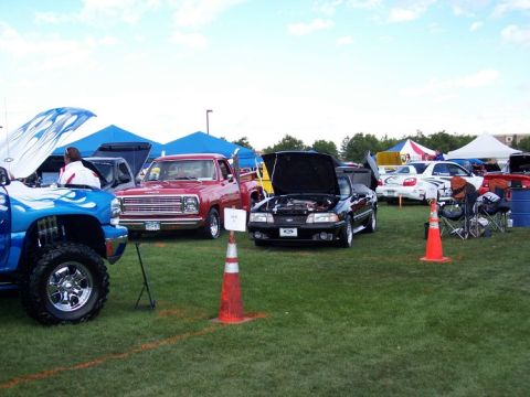 1972 Ford Ranchero - Outdoor car show features a variety of vehicles including trucks, a Mustang, and a Subaru.