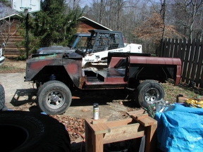 1974 Ford Bronco - This 1974 Ford Bronco appears to be undergoing significant modifications, possibly a tub swap, with a Bobcat loader visible in the backgrou…