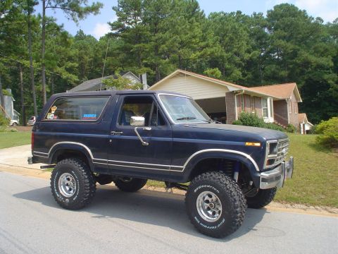 1984 Ford Bronco - This lifted Ford Bronco is parked in front of a suburban house.